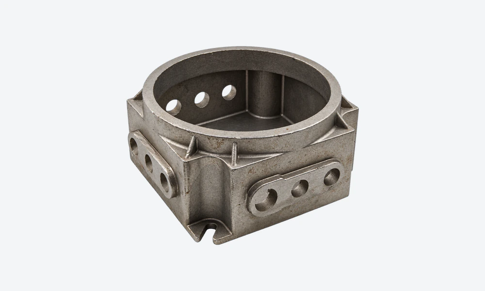 Carbon steel housing casting with a circular opening, integral ribs and grouped openings in raised side pads.